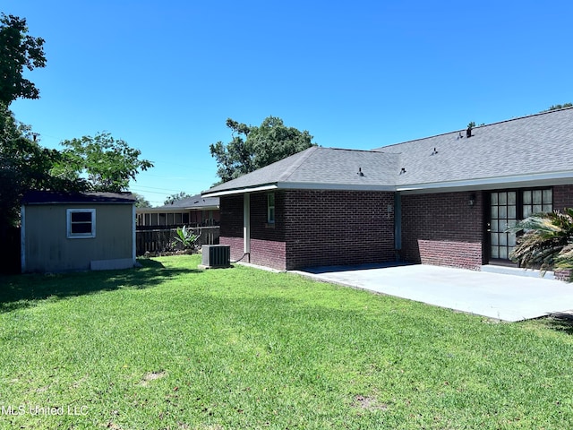 view of yard with central air condition unit, a patio area, and a storage shed