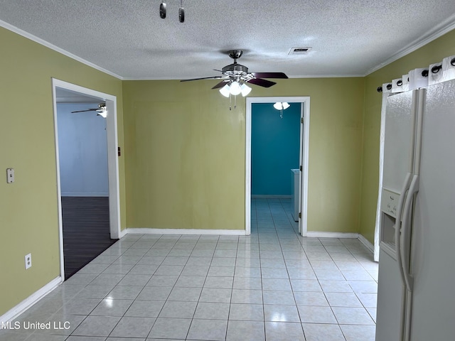 tiled empty room with ornamental molding and a textured ceiling