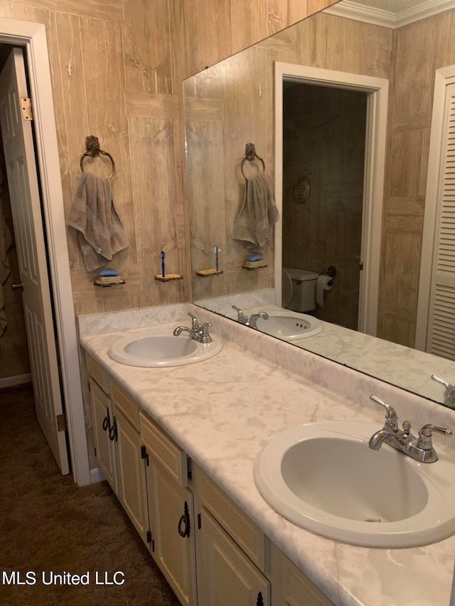 bathroom with vanity, crown molding, toilet, and wooden walls