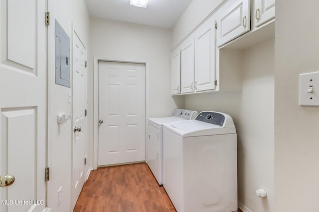 8921 Hanalei Cir, Diamondhead, MS 39525 - laundry room featuring washing machine and dryer, electric panel, cabinet space, and light wood-style floors