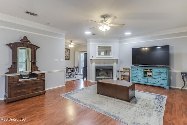 8921 Hanalei Cir, Diamondhead, MS 39525 - living area featuring ceiling fan, wood finished floors, a tile fireplace, plenty of natural light, and ornamental molding