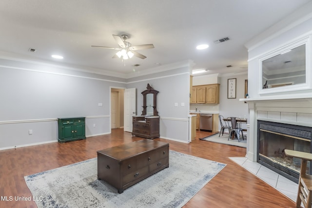 8921 Hanalei Cir, Diamondhead, MS 39525 - living room featuring ceiling fan, wood finished floors, ornamental molding, a tile fireplace, and recessed lighting