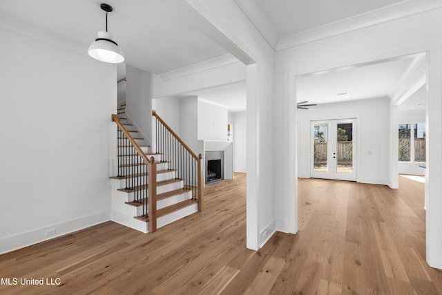 entryway featuring stairs, light wood finished floors, ornamental molding, and baseboards