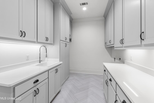 laundry area with recessed lighting, a sink, visible vents, baseboards, and cabinet space