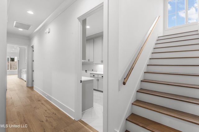 stairs with baseboards, visible vents, wood finished floors, and recessed lighting