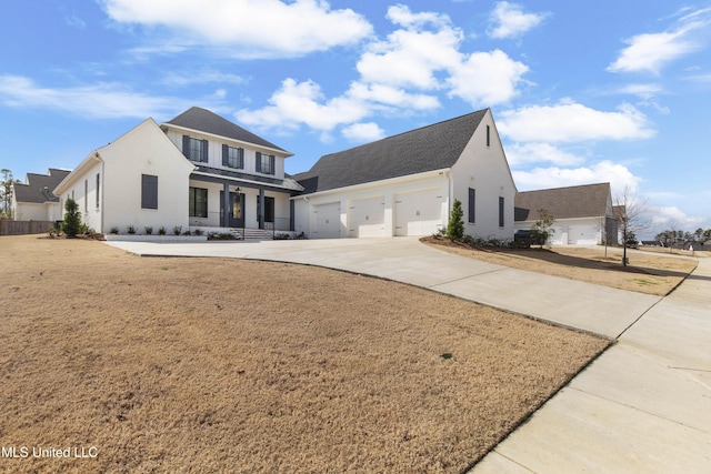 view of front facade with covered porch, concrete driveway, an attached garage, and a front yard