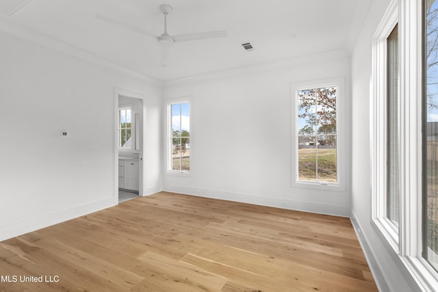 unfurnished room featuring ornamental molding, plenty of natural light, a ceiling fan, and light wood-style floors