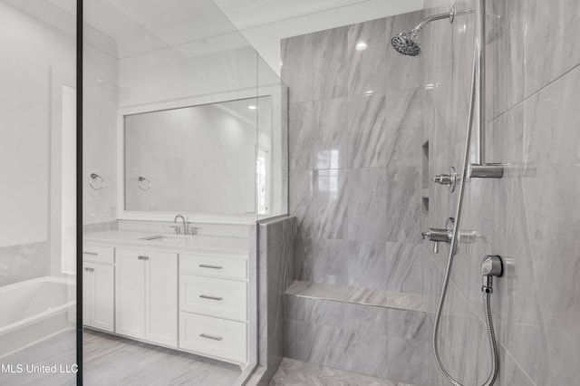 bathroom with a bathing tub, tiled shower, and vanity