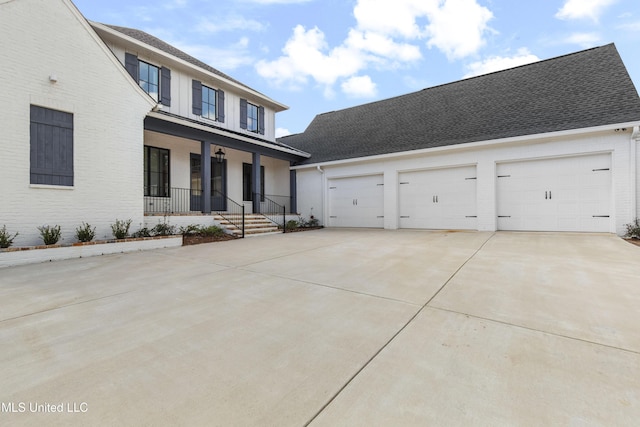 view of front of house featuring a garage, covered porch, concrete driveway, and brick siding