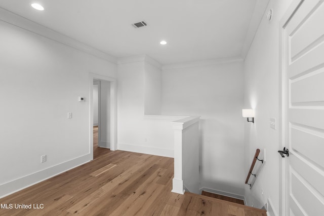 interior space with ornamental molding, visible vents, light wood-style flooring, and baseboards