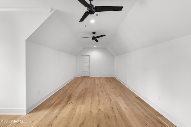 bonus room with lofted ceiling, visible vents, light wood-style flooring, and baseboards