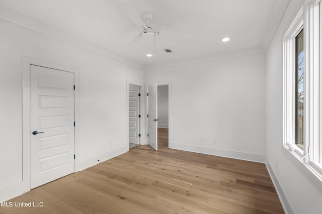 unfurnished bedroom with light wood-type flooring, crown molding, baseboards, and recessed lighting