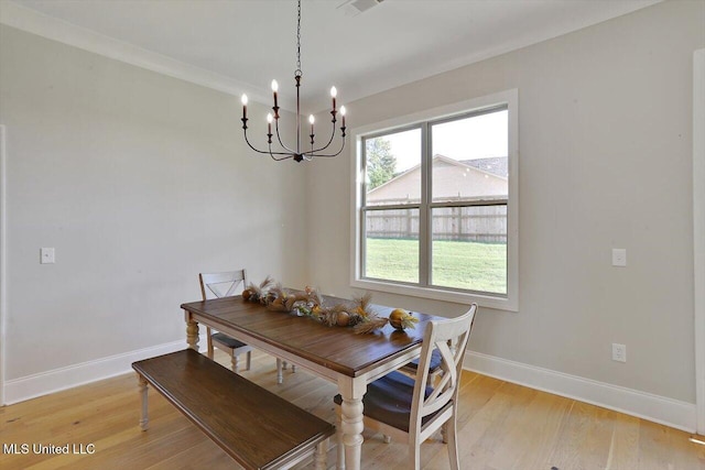 dining room with light wood finished floors, visible vents, a notable chandelier, and baseboards