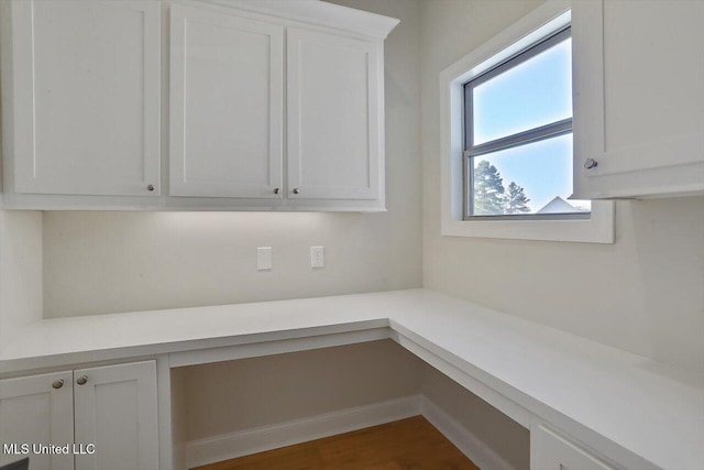 interior space with built in desk and dark hardwood / wood-style floors