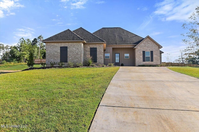view of front facade with a front lawn, driveway, and brick siding