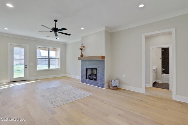 unfurnished living room with ornamental molding, a ceiling fan, wood finished floors, and a brick fireplace