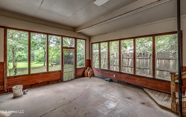 unfurnished sunroom with vaulted ceiling with beams