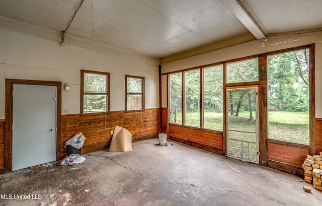 unfurnished sunroom with beam ceiling and plenty of natural light