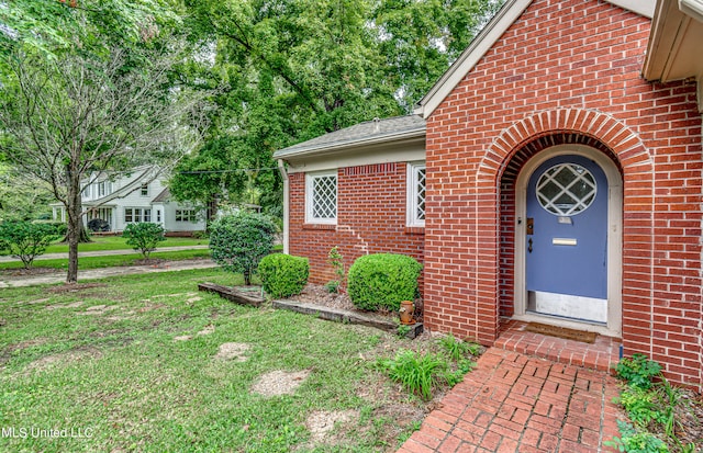 view of exterior entry with a yard