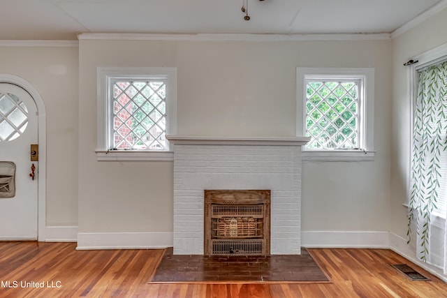 entrance foyer featuring crown molding, wood-type flooring, and a wealth of natural light