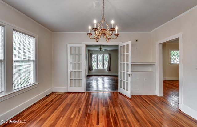 unfurnished dining area with french doors, crown molding, wood-type flooring, and ceiling fan with notable chandelier