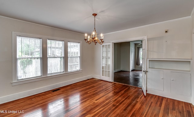 unfurnished dining area featuring crown molding, a chandelier, and dark hardwood / wood-style flooring