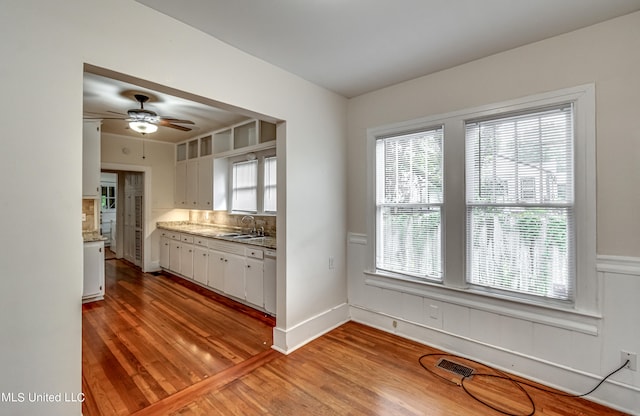 kitchen featuring sink, backsplash, ceiling fan, white cabinets, and light hardwood / wood-style flooring