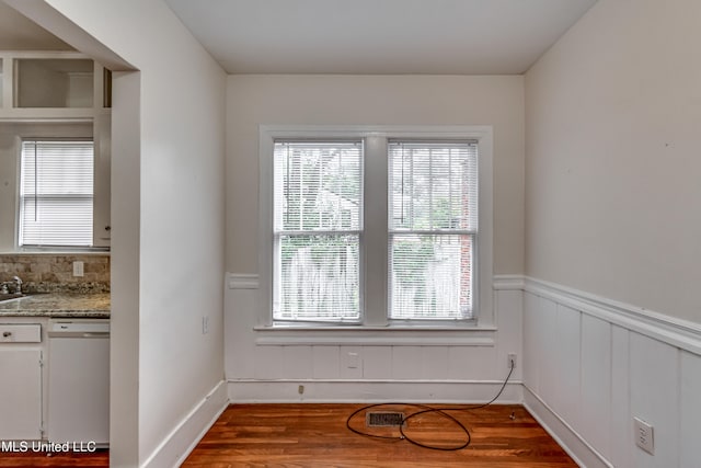 unfurnished dining area with sink and hardwood / wood-style floors