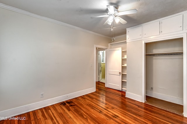 unfurnished bedroom featuring a closet, ornamental molding, ceiling fan, and dark hardwood / wood-style flooring