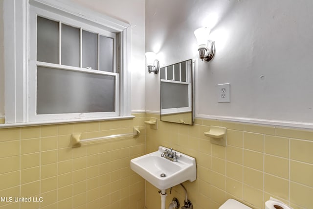 bathroom with tile walls and sink