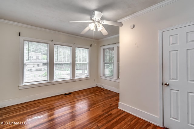 spare room featuring dark wood-type flooring, crown molding, and ceiling fan