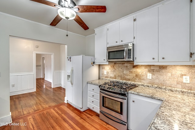 kitchen with decorative backsplash, crown molding, appliances with stainless steel finishes, light hardwood / wood-style floors, and ceiling fan