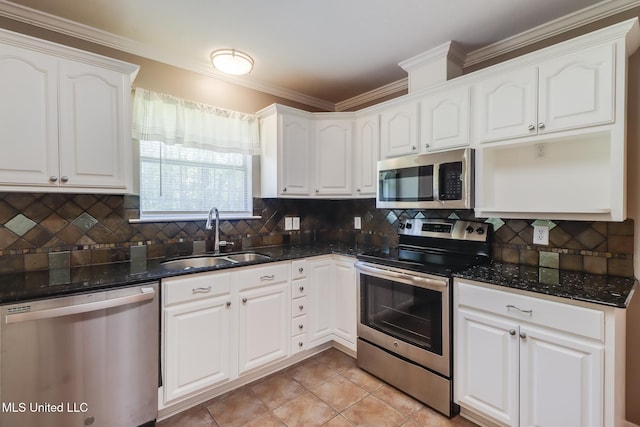 28121 Dusty Ln, Picayune, MS 39466 - kitchen featuring stainless steel appliances, a sink, dark stone countertops, crown molding, and white cabinetry