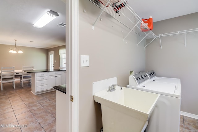 28121 Dusty Ln, Picayune, MS 39466 - laundry room featuring washer and dryer, light tile patterned flooring, baseboards, and a chandelier