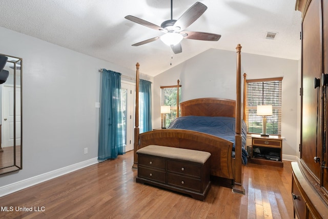 bedroom with multiple windows, ceiling fan, vaulted ceiling, and light hardwood / wood-style flooring