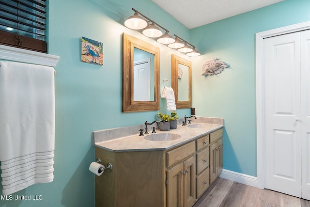 bathroom featuring a textured ceiling, wood-type flooring, and vanity