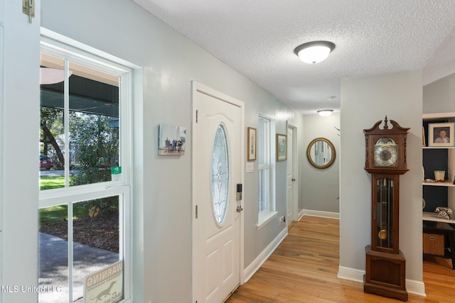 entryway featuring light wood-type flooring and a textured ceiling