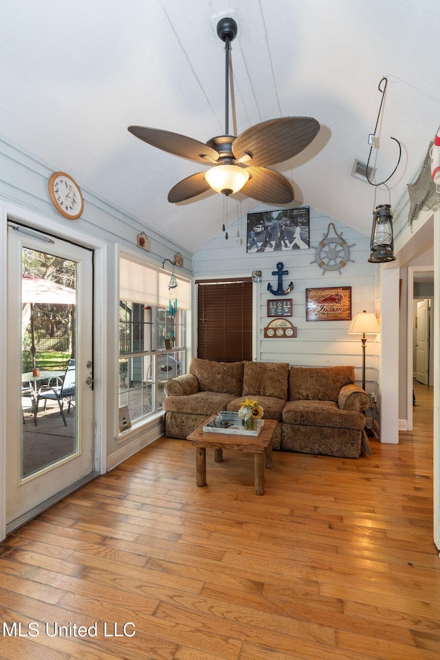 living room with light hardwood / wood-style floors, ceiling fan, and lofted ceiling