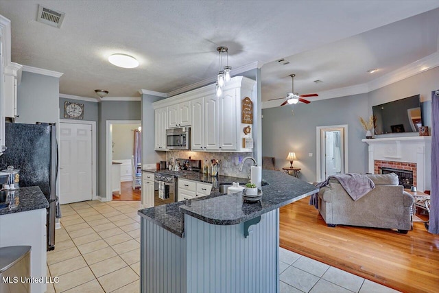 kitchen featuring kitchen peninsula, white cabinetry, stainless steel appliances, and sink