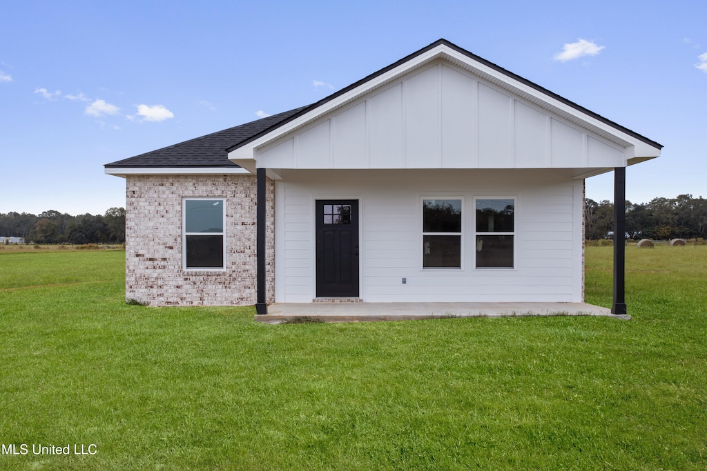 back of property featuring a lawn