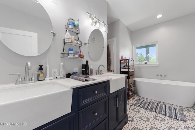 19640 Busby Rd, Vancleave, MS 39565 - bathroom featuring a freestanding bath, a sink, double vanity, and recessed lighting