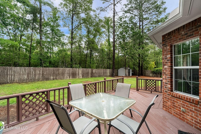 32 Cambrooke, Hattiesburg, MS 39402 - deck with outdoor dining area, a storage unit, an outdoor structure, and view of scattered trees