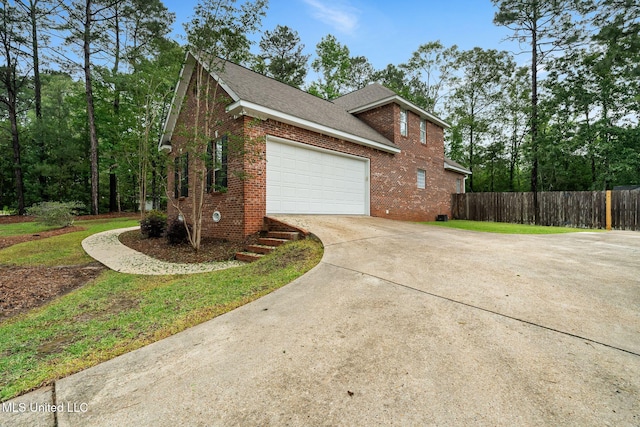 32 Cambrooke, Hattiesburg, MS 39402 - view of property exterior with brick siding, driveway, fence, a garage, and roof with shingles