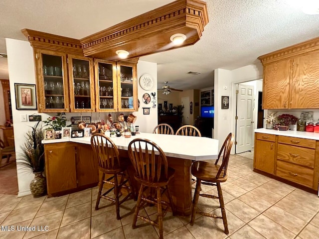 tiled dining room with ceiling fan and a textured ceiling