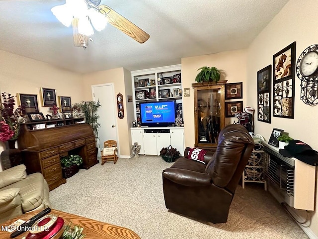 living room featuring ceiling fan, carpet flooring, and a textured ceiling