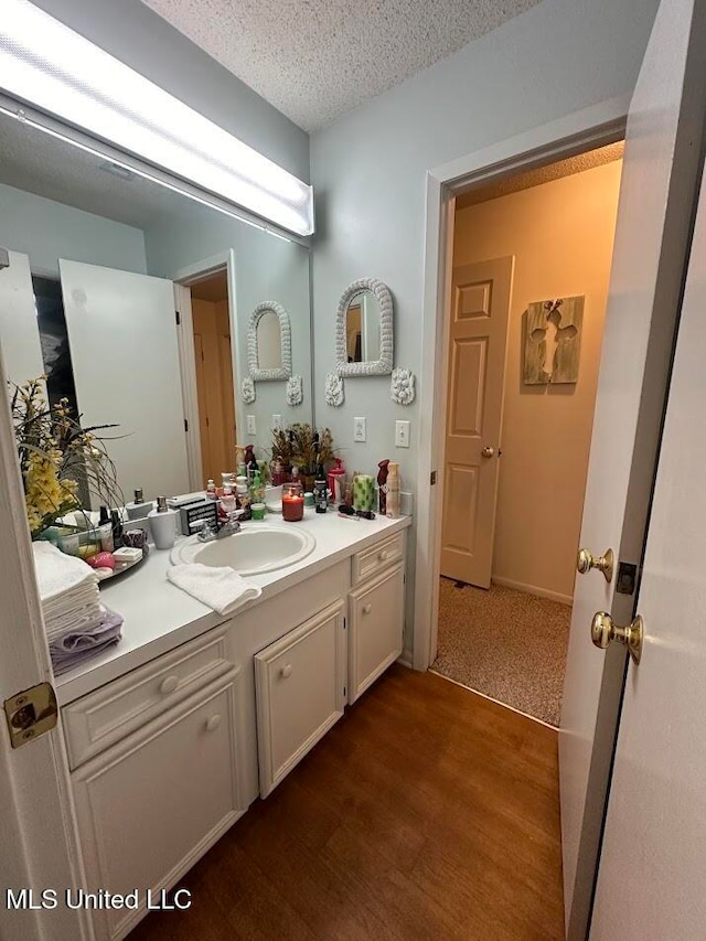 bathroom featuring vanity, a textured ceiling, and hardwood / wood-style flooring