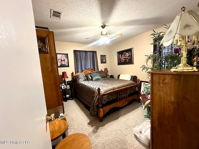 bedroom with ceiling fan, carpet, and a textured ceiling