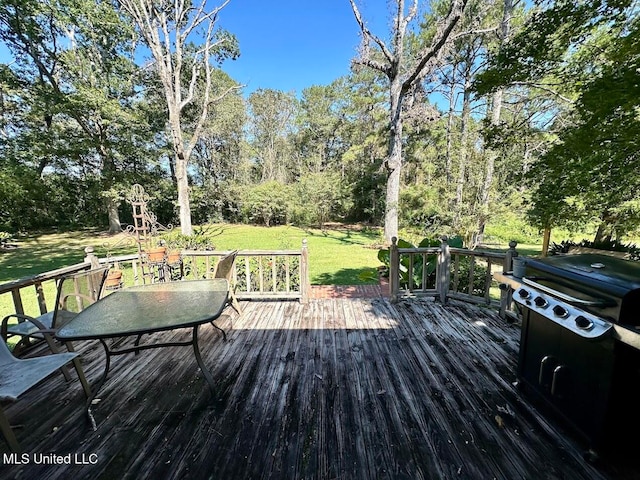 wooden terrace featuring grilling area and a lawn