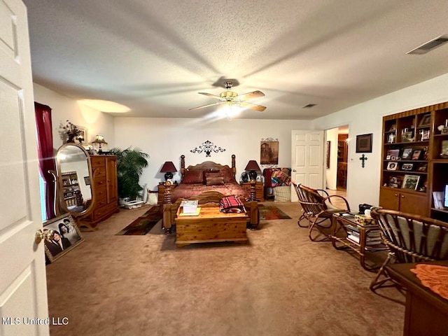 bedroom with ceiling fan, carpet flooring, and a textured ceiling