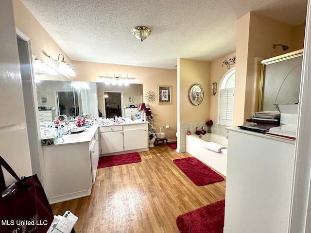 bathroom with vanity, hardwood / wood-style floors, independent shower and bath, and a textured ceiling